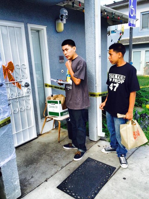 two men holding clipboard and bag outside a house